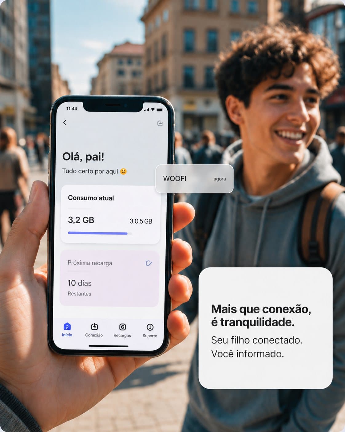 Jovem intercambista sorrindo em uma rua movimentada enquanto mostra no celular o app da Woofi, com a mensagem “Olá, pai!”, o consumo de dados do plano e os dias até a próxima recarga