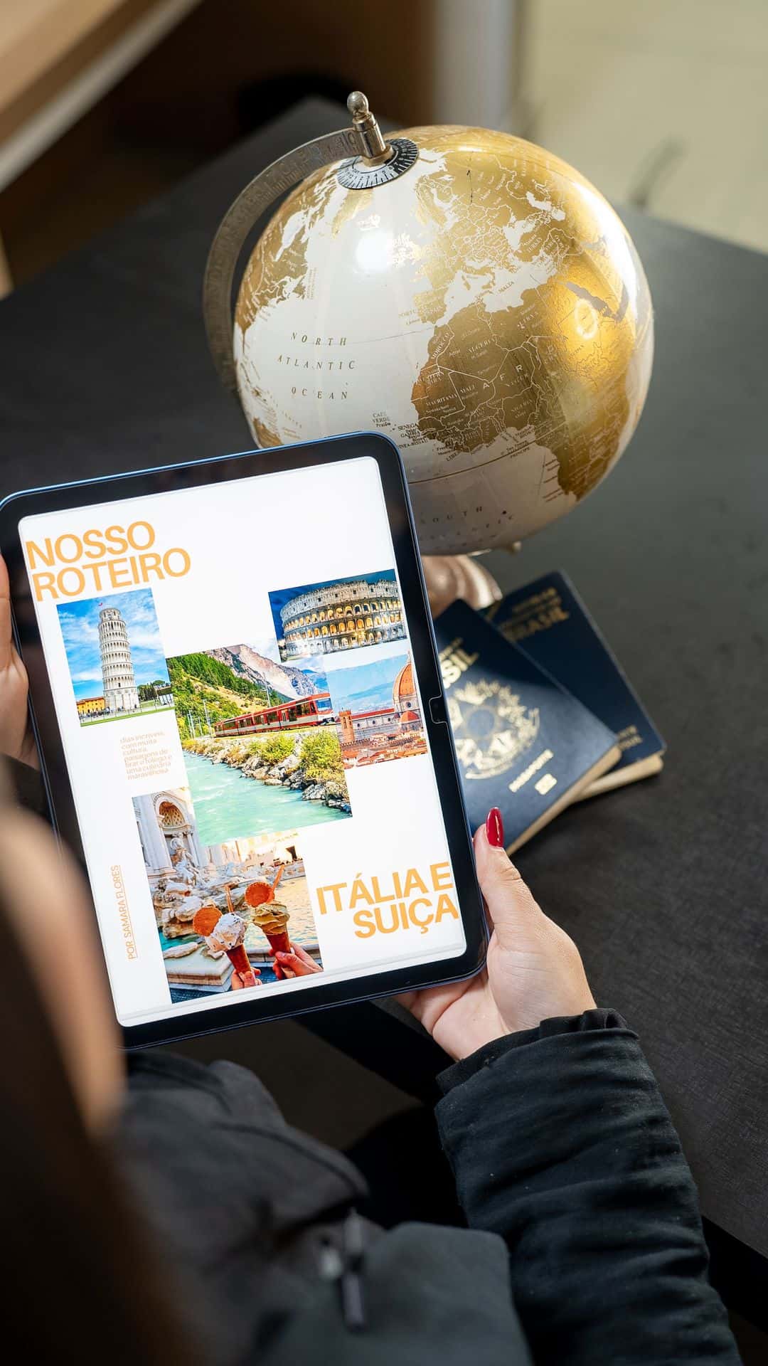 Intercambista segurando tablet com roteiro de viagem da Itália e Suíça ao lado de passaportes brasileiros